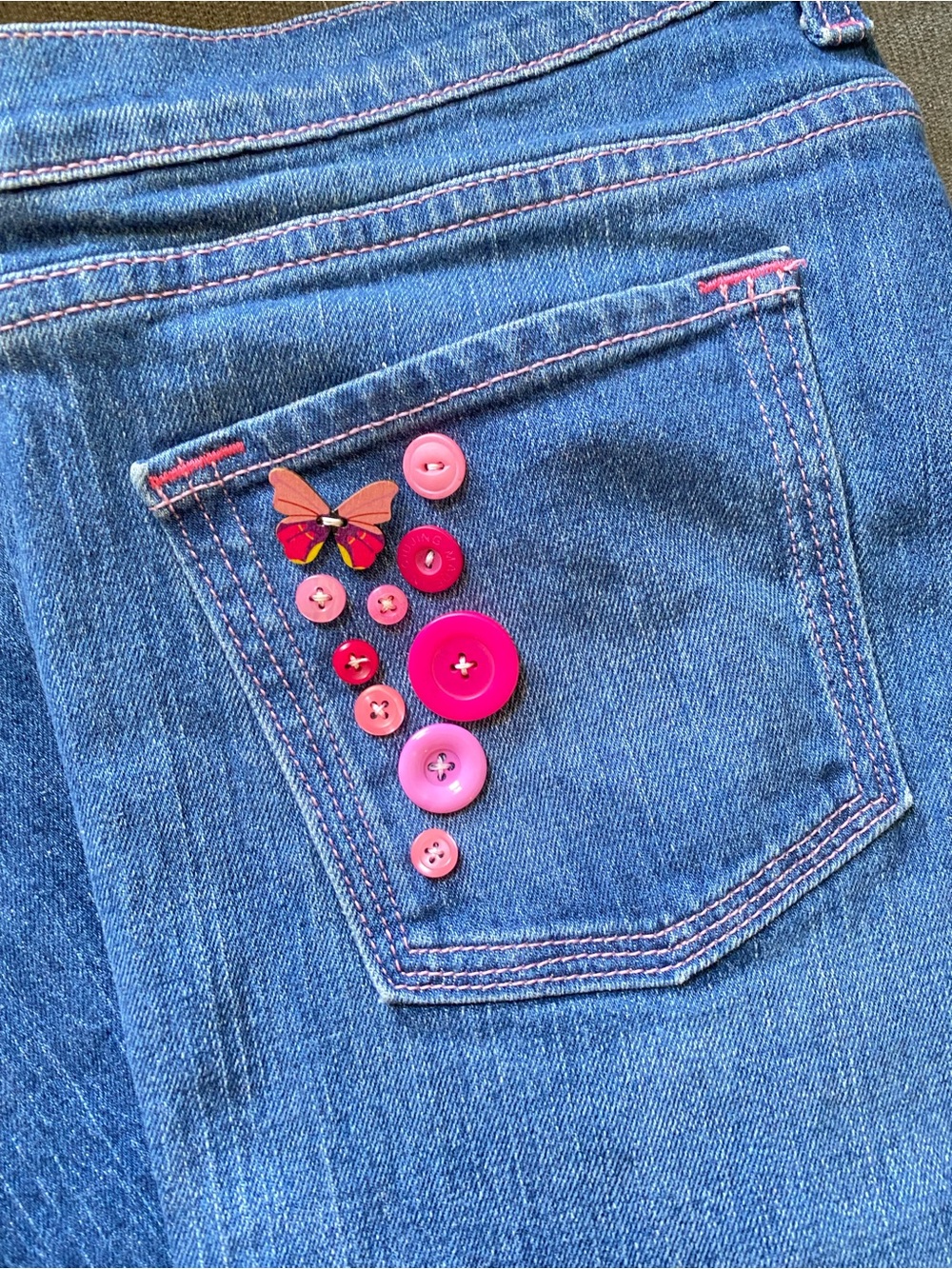 Pink stitched jeans with pink buttons
